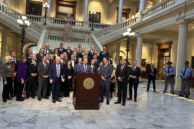 Governor Brian Kemp and other Georgia lawmakers stand on the steps of the Georgia Capitol at a press conference.